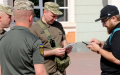 Representatives of the territorial recruitment and social support center hand the man a summons on the street. Photo: armyinform
