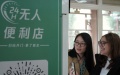 Maria (R), a Brazilian student, scans a QR code on a vending machine at the Yenching Academy of Peking University in Beijing, capital of China. Photo by Xinhua/Ren Chao.