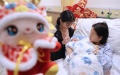A newborn baby is seen with the mother and sister at a hospital in Wuxi, east China's Jiangsu Province. Photo by Zhu Jipeng/Xinhua.
