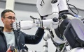 A researcher adjusts a humanoid robot at an AI laboratory.  Photo by Xinhua/Chen Yehua.