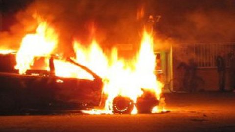 Молодежь поджигает автомобили и забрасывает камнями полицейских.