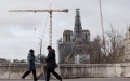 People walk past the Notre Dame Cathedral under renovation in Paris, France. Photo by Xinhua/Gao Jing.