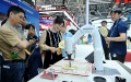 People watch as an AI-powered robotic arm writes with a brush at the hand-on experience area during the 7th Digital China Summit in Fuzhou, southeast China's Fujian Province. Photo by Xinhua/Lin Shanchuan.