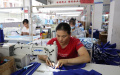 Residents of Huanjiang Maonan Autonomous County, Guangxi Zhuang Autonomous Region work in a garment factory. Photo by Xinhua.