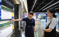 A consumer (right) learns about trade-in plans for home appliances at a store in Chongqing. Photo by Xinhua.