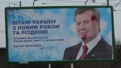 Билборд с новогодним поздравлением Президента, испачканый краской.