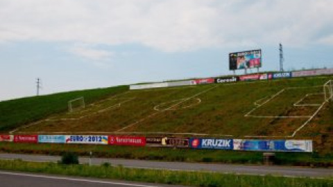 Вдоль площадки на склоне горы установлено много рекламных щитов.