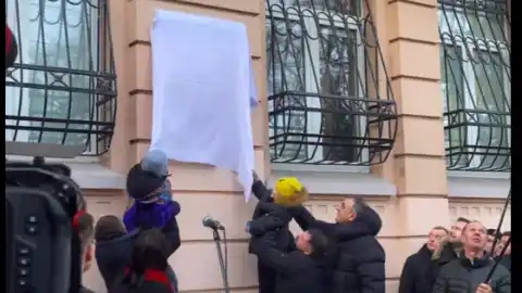 Внуки Ірини Фаріон Дмитро та Ева відкривають табличку з назвою вулиці на честь своєї бабусі. Скріншот відео