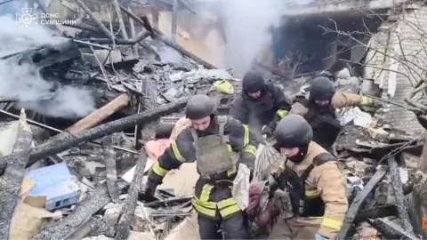 Спасатели достают тело женщины из-под завалов дома. Скриншот видео