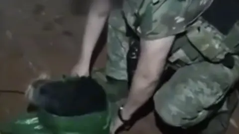 Военные достают из мешка собаку, которую эвакуировали с помощью БПЛА. Фото: скриншот.