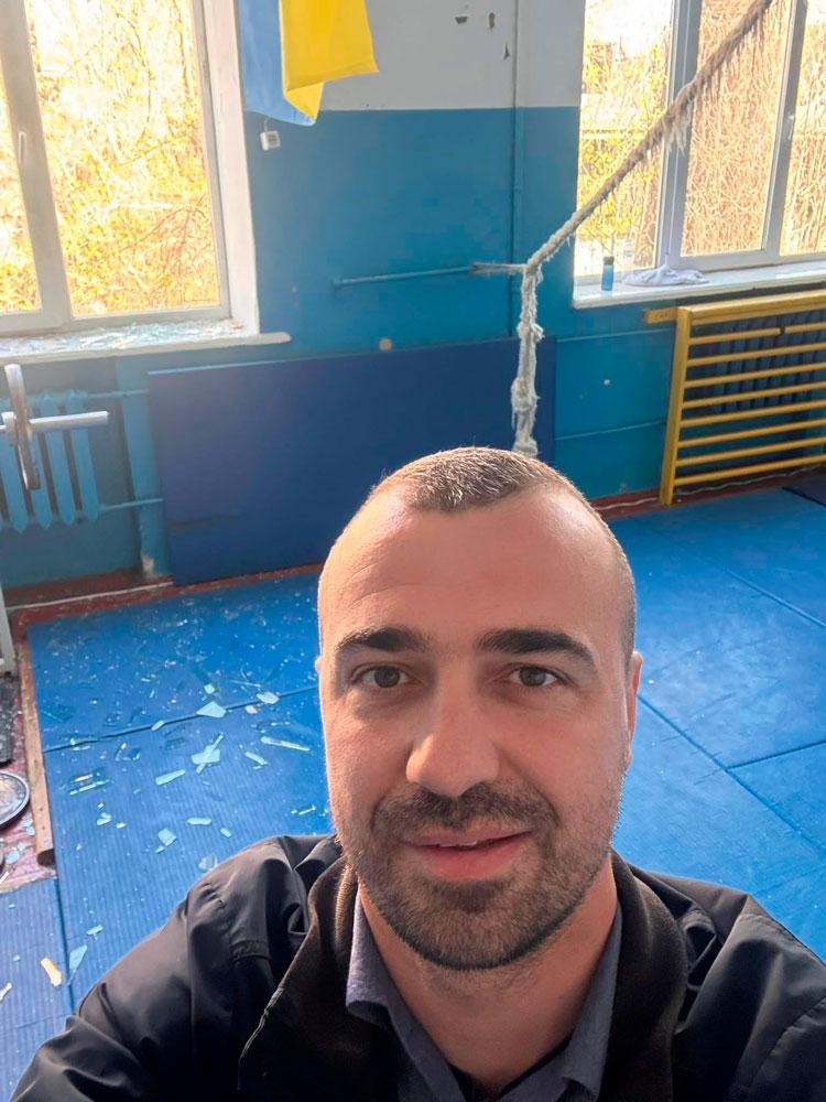 Данило Міро на тлі розбитих вікон спортивної зали. Фото: facebook.com/danylo.miro
