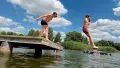 Ребята прыгают в воду на пляже. Фото: Денис Гороховский/Украинские Новости