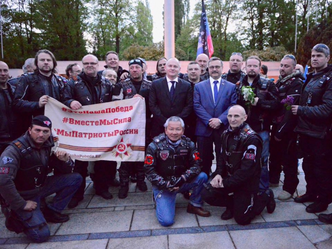 Гашек (в черном костюме) сфотографировался с Ночными волками на фоне флага ДНР